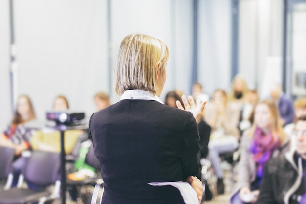 Vrouwelijke spreker die een lezing geeft op zakelijke zakelijke conferentie Onherkenbare mensen in publiek in conferentiezaal Business and Entrepreneurship-evenement