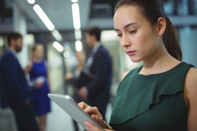 Vrouwelijke stafmedewerker met behulp van digitale tablet in gang