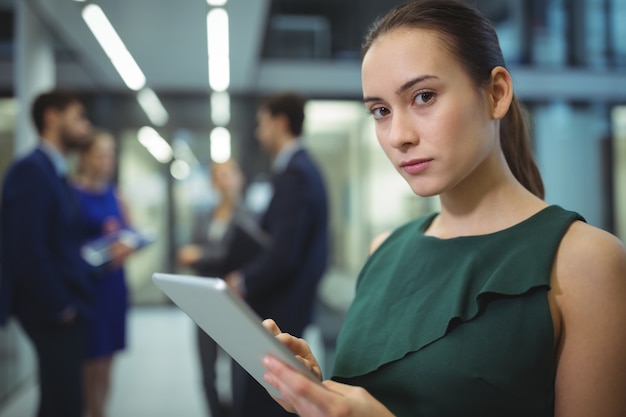 Vrouwelijke stafmedewerker met behulp van digitale tablet in gang