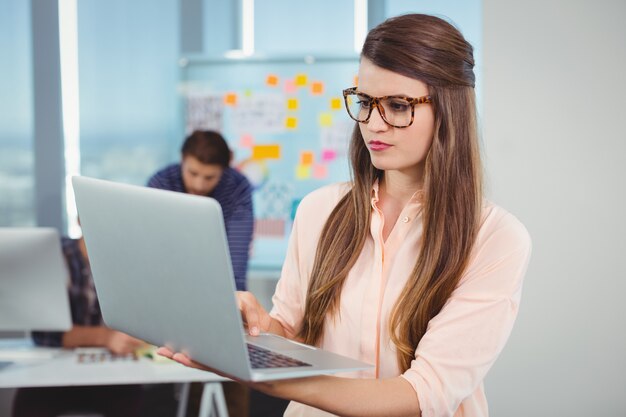 Vrouwelijke stafmedewerker met behulp van laptop