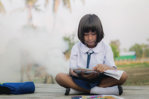 Vrouwelijke student die een boek leest.