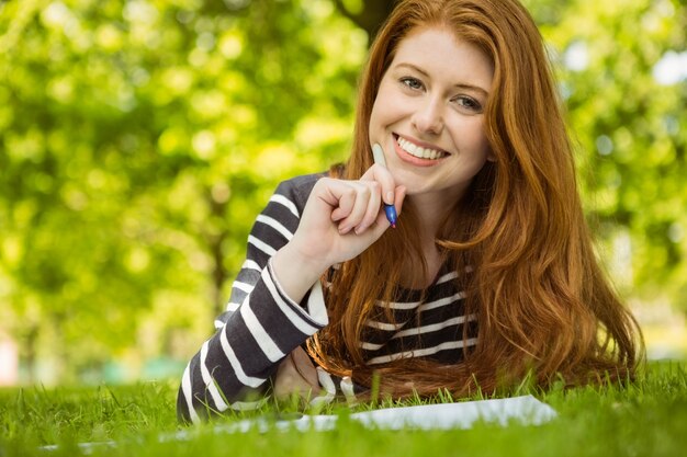 Vrouwelijke student die thuiswerk in park doet