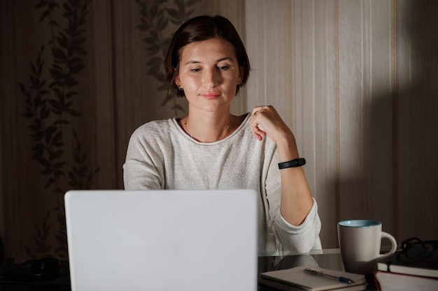 Vrouwelijke student freelancer die thuis aan een taak werkt