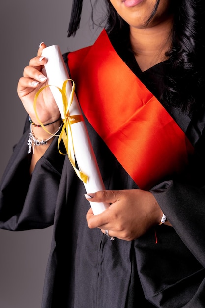 Vrouwelijke student in een afstudeerfoto einde van de opleiding met een afgestudeerd diploma universiteit met een zwart gewaad met een diploma met de hand