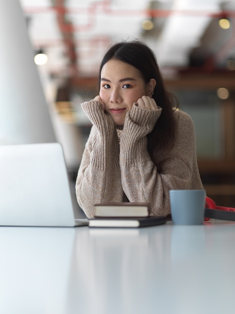 Vrouwelijke student in sweater glimlachen