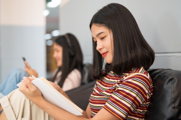 Vrouwelijke student las een boek bij Bibliotheek