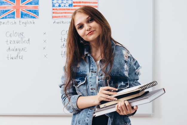 Vrouwelijke student met boeken in de klas Engelse talenschool.