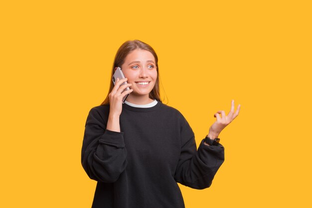 Vrouwelijke student praat aan de telefoon en gebaren.