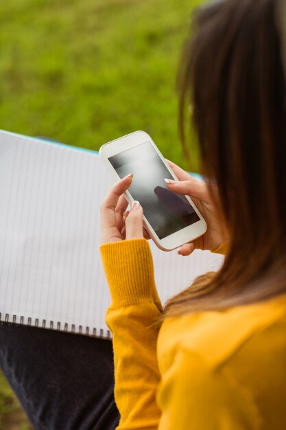 Vrouwelijke student sms-berichten in park