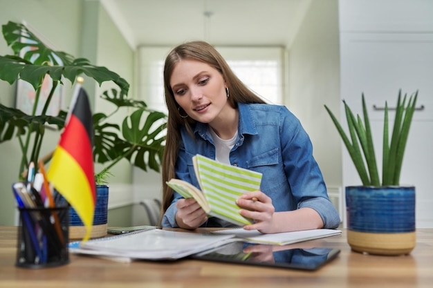 Vrouwelijke studente die met de webcam praat en Duits online studeert
