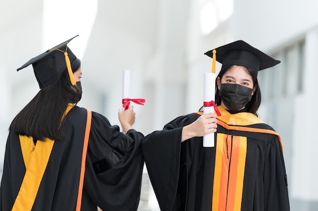 Vrouwelijke studenten, universitair afgestudeerden, dragen zwarte hoeden, gele kwastjes en dragen maskers tijdens de epidemie.