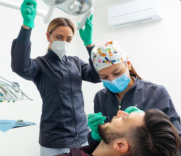 Vrouwelijke tandarts onderzoekt een mannelijke patiënt in een tandartspraktijk