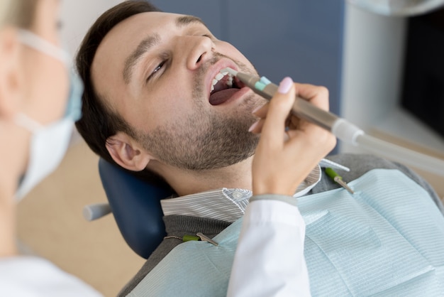 Vrouwelijke tandarts vullen holtes