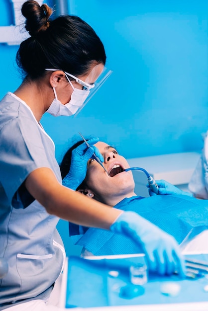Vrouwelijke tandartsen die een vrouw in de kliniek onderzoeken
