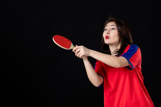 Vrouwelijke tennisspeler met racket op zwart