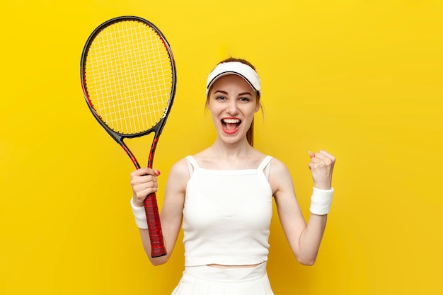 Vrouwelijke tennisspeler winnaar in sportkleding houdt een tennisracket vast en verheugt zich over de overwinning