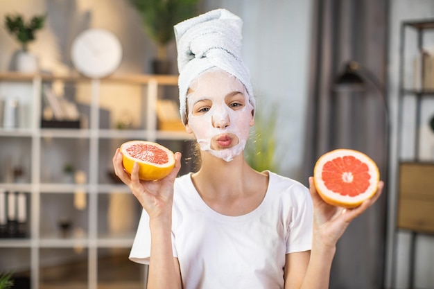Vrouwelijke tiener met masker op gezicht met plakjes citrus