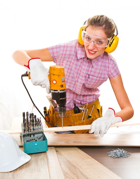 Vrouwelijke timmerman aan het werk met behulp van hand boren machine