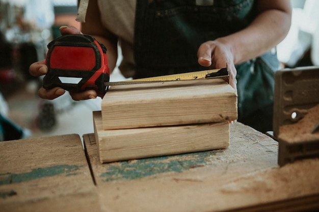 Vrouwelijke timmerman die het hout meet