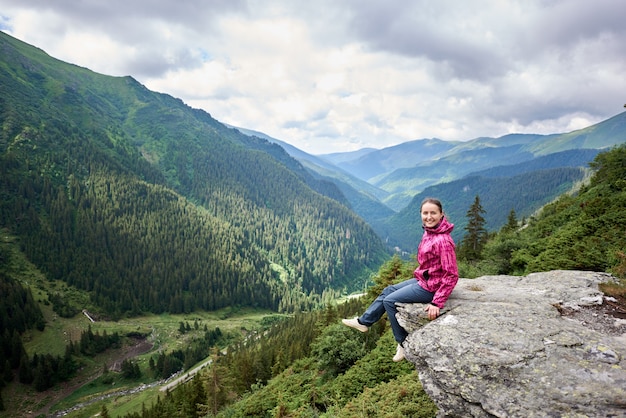 Vrouwelijke toerist bovenop heuvel in de bergen