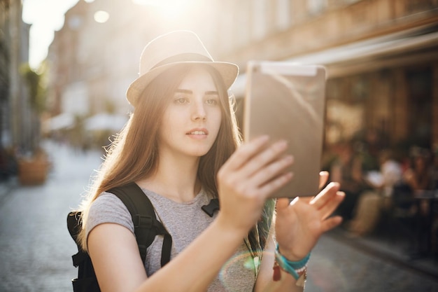 Vrouwelijke toerist die een tablet gebruikt om naar interessante locaties te zoeken of haar weg te vinden of gewoon chat met vrienden via video Reisconcept