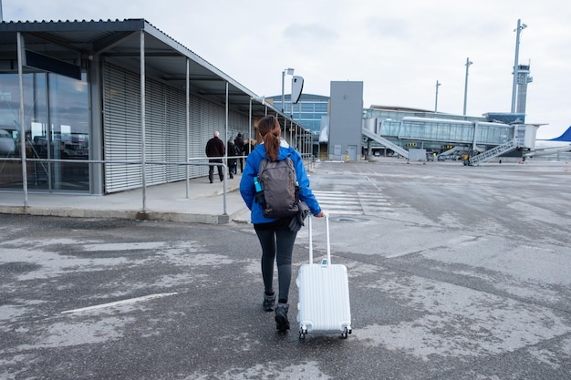 Vrouwelijke toerist die met bagage liep, arriveerde op de landingsbaan op de luchthaven