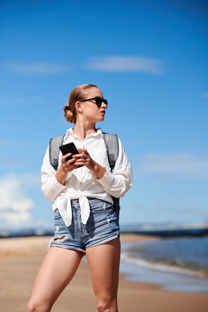 Vrouwelijke toerist die op het strand staat