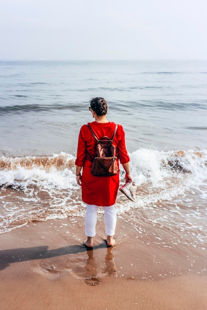 Vrouwelijke toerist die rust van het wandelen aan de kust