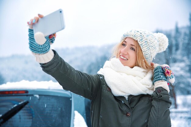 Vrouwelijke toerist die selfie neemt op het besneeuwde platteland