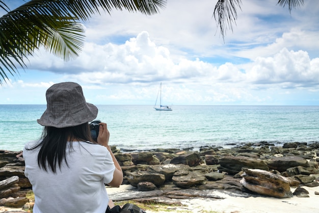 Vrouwelijke toeristen maken foto's op het strand.