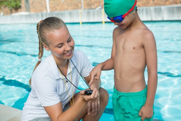 Vrouwelijke trainer chronometer tonen aan jongen