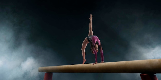 Vrouwelijke turnster doet een ingewikkelde truc op gymnastiek-evenwichtsbalk in een professionele arena