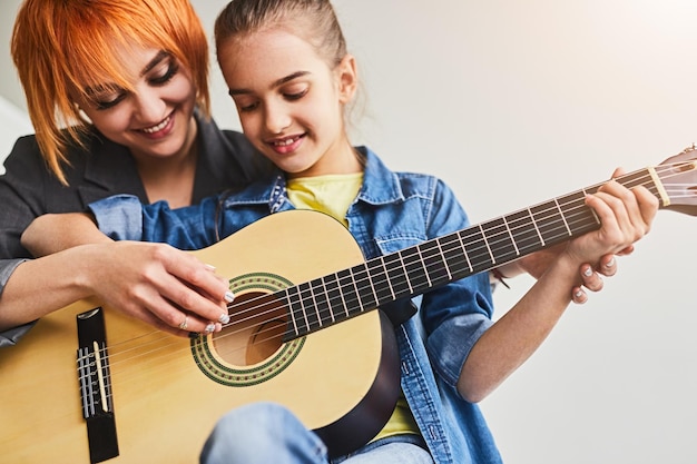 Vrouwelijke tutor die student leert gitaar te spelen