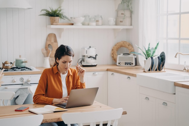 Vrouwelijke verkoopmanager werkt vanuit huis Lady freelancer met laptop maakt aantekeningen