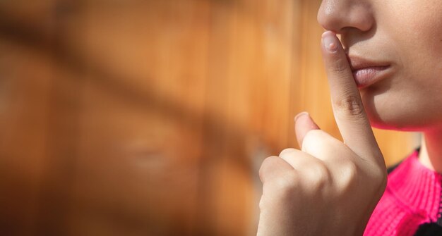 Vrouwelijke vinger op haar lippen Stilte