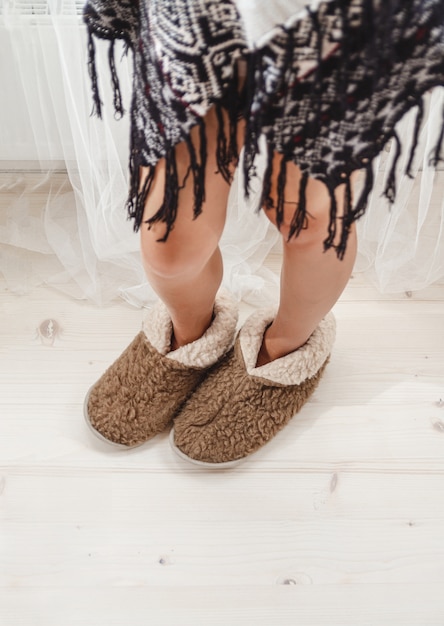 Vrouwelijke voeten in warme gezellige pantoffels thuis