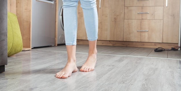 Vrouwelijke voeten lopen op de vloer thuis