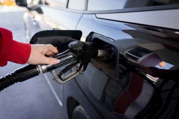 Vrouwelijke vullende benzine in een auto