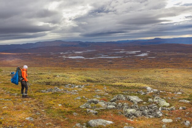 Vrouwelijke wandelaar met rugzak op kungsleden-pad dat de natuur van sarek bewondert