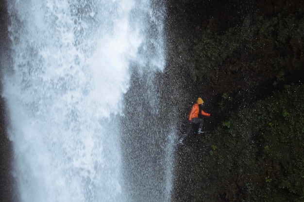 Vrouwelijke wandelaar met uitzicht op de kvernufoss-waterval in zuid-ijsland