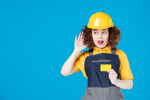 Vrouwelijke werknemer in uniform met creditcard op een blauw