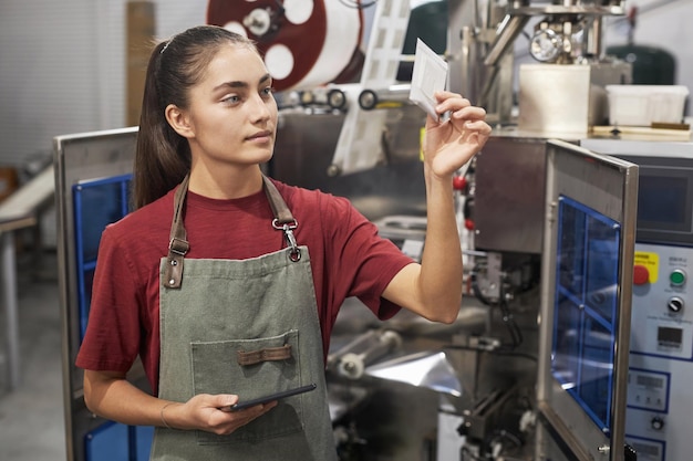Vrouwelijke werknemer met een koffiebak in een productiefabriek