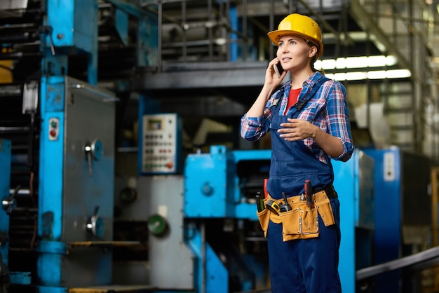 Vrouwelijke werknemer spreken via de telefoon in de fabriek Workshop