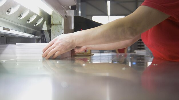 Vrouwelijke werknemer vouwt een stapel papier in de typografie