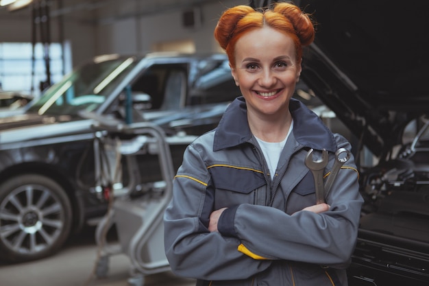 Vrouwelijke werktuigkundige die bij autobenzinestation werkt