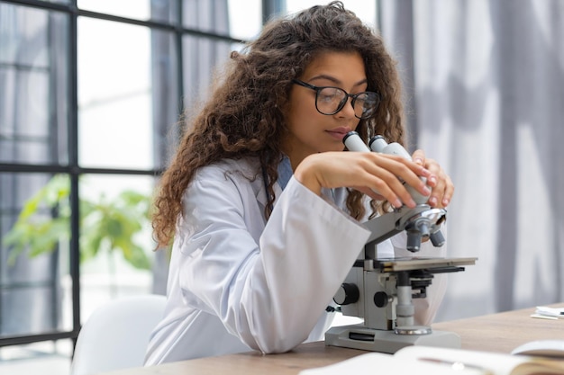 Vrouwelijke wetenschapper in medicijnjas werkt in een wetenschappelijk laboratorium
