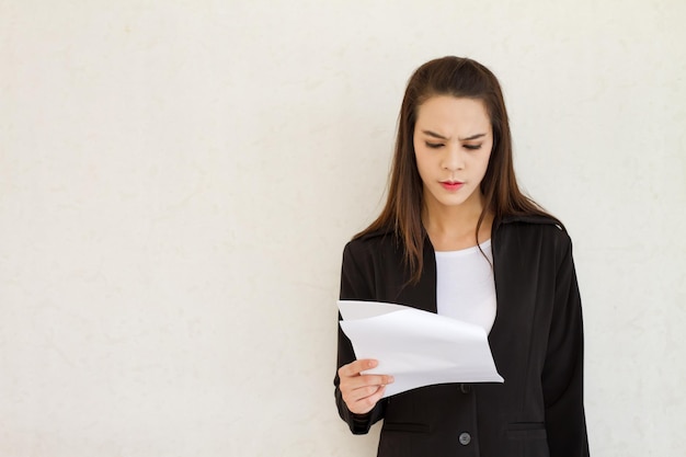 Vrouwelijke zakenman die met stress naar het document kijkt