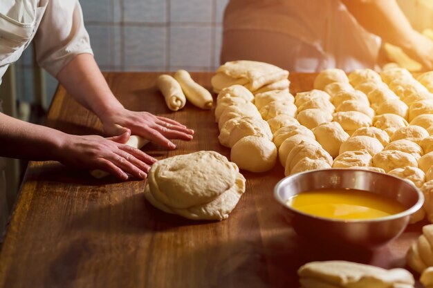 Vrouwen bakken taarten banketbakkers maken toetjes broodjes maken deeg op tafel kneed het deeg