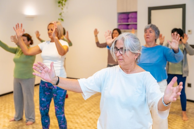 Vrouwen bewegen gecoördineerd het sluiten van een qi gong klas