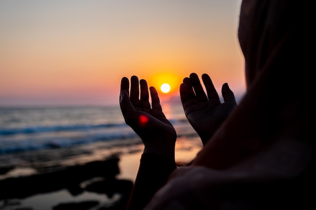 Vrouwen bidden tot allah op het strand bij zonsondergang